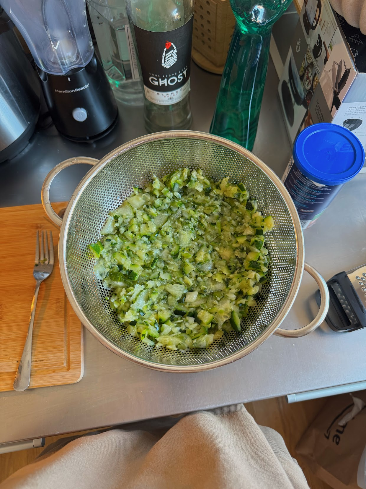Drained zucchini and cucumber in a colander